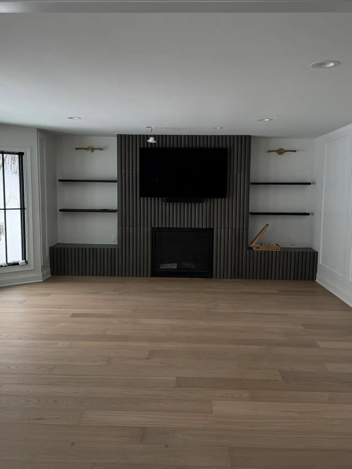 Living room after — fireplace wall with open shelving