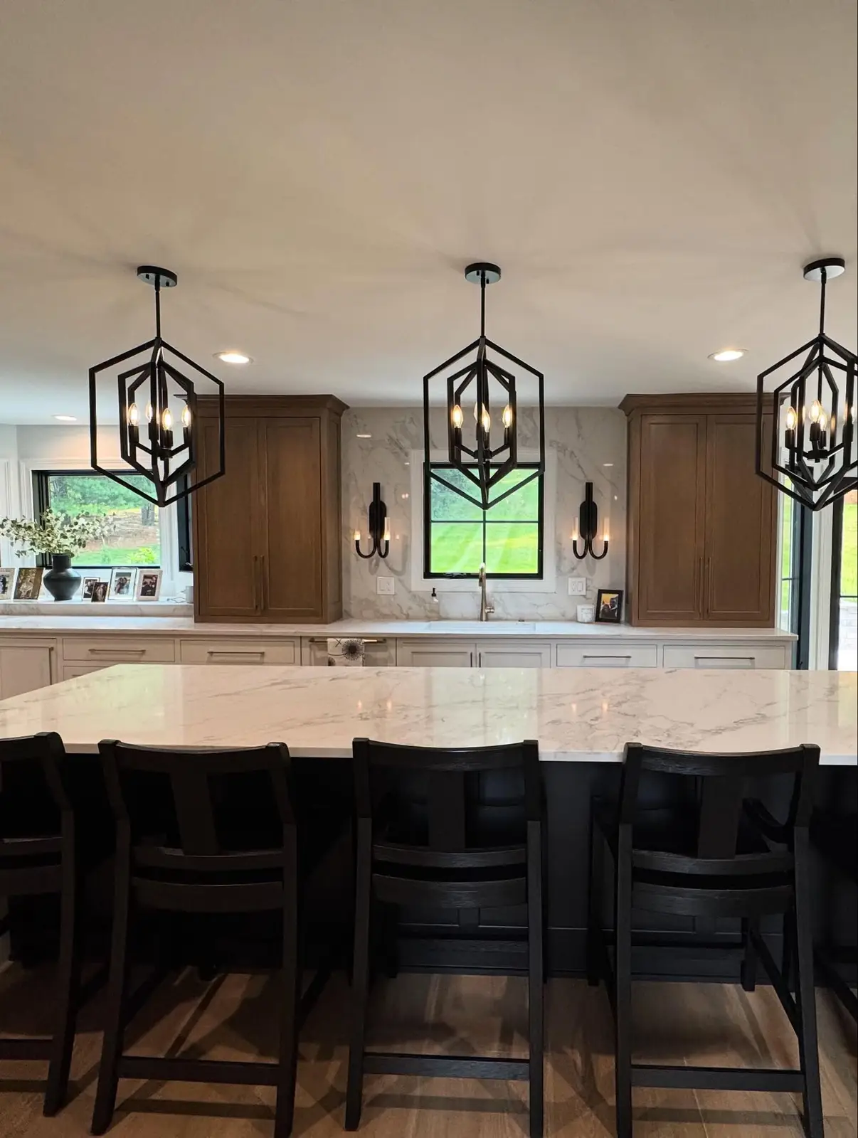 Renovated kitchen with island seating beneath lantern pendants