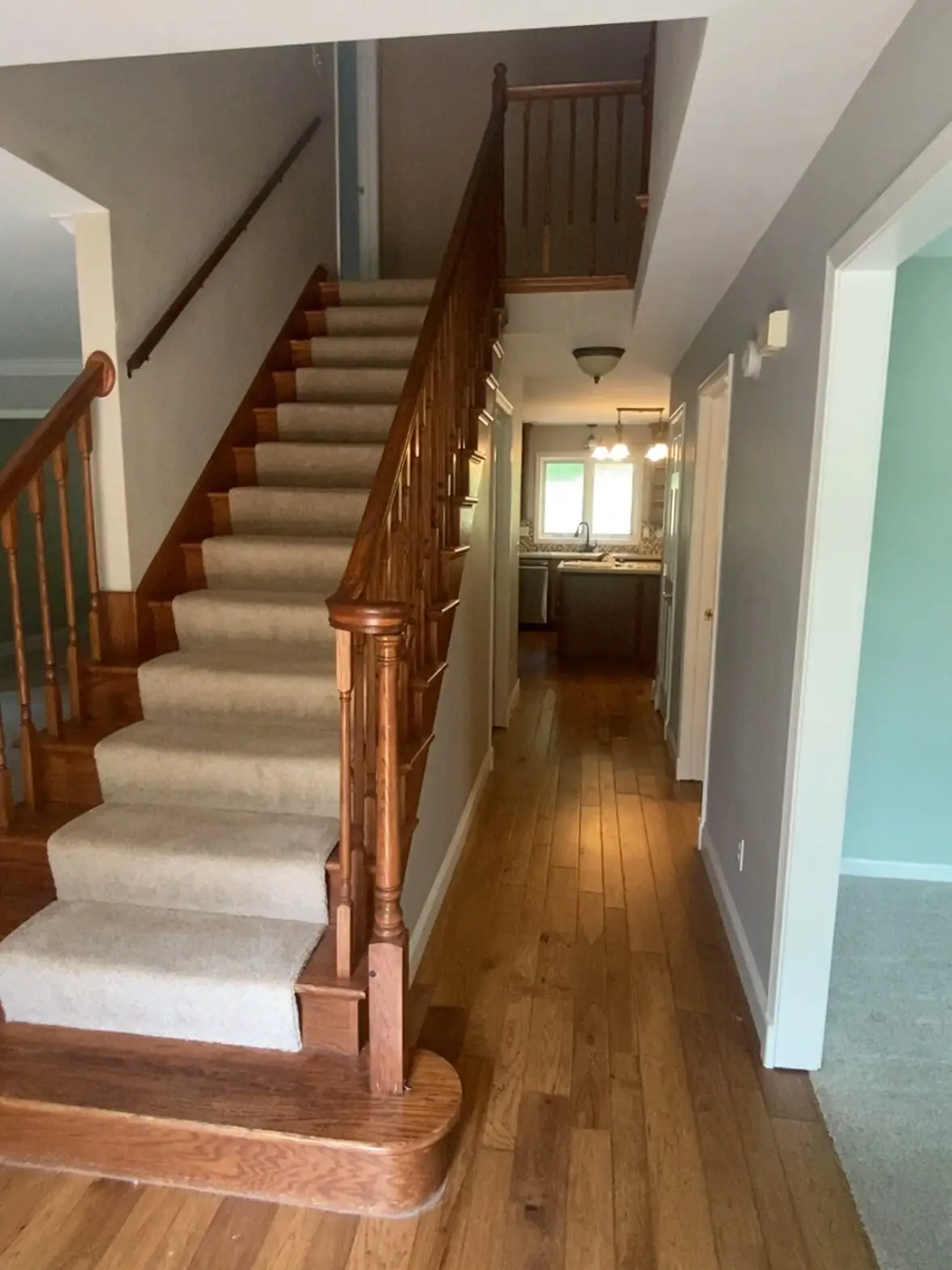 Staircase before — carpeted stairs and wood railing