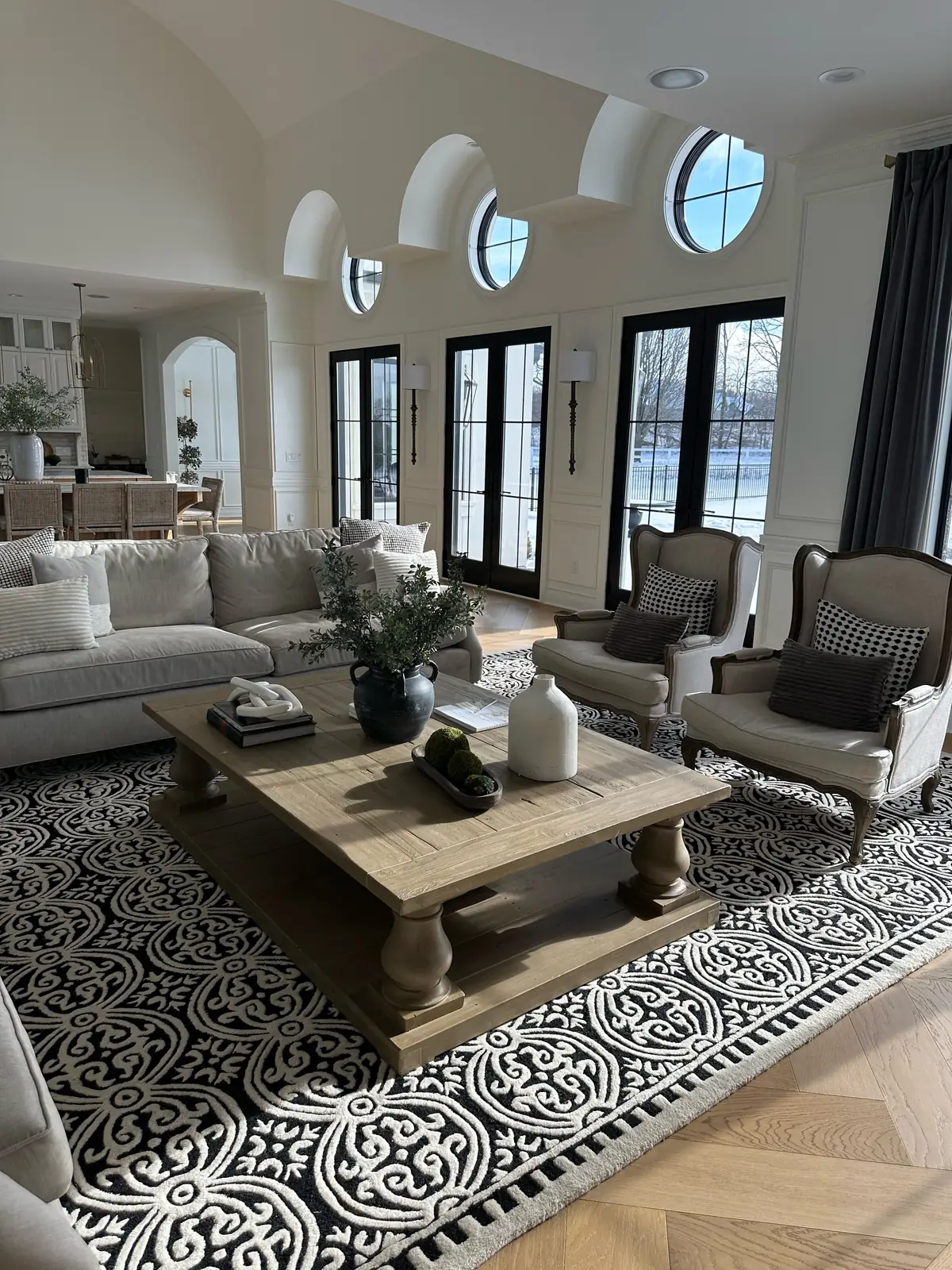Great room beneath arched dormers — French-Inspired Residence