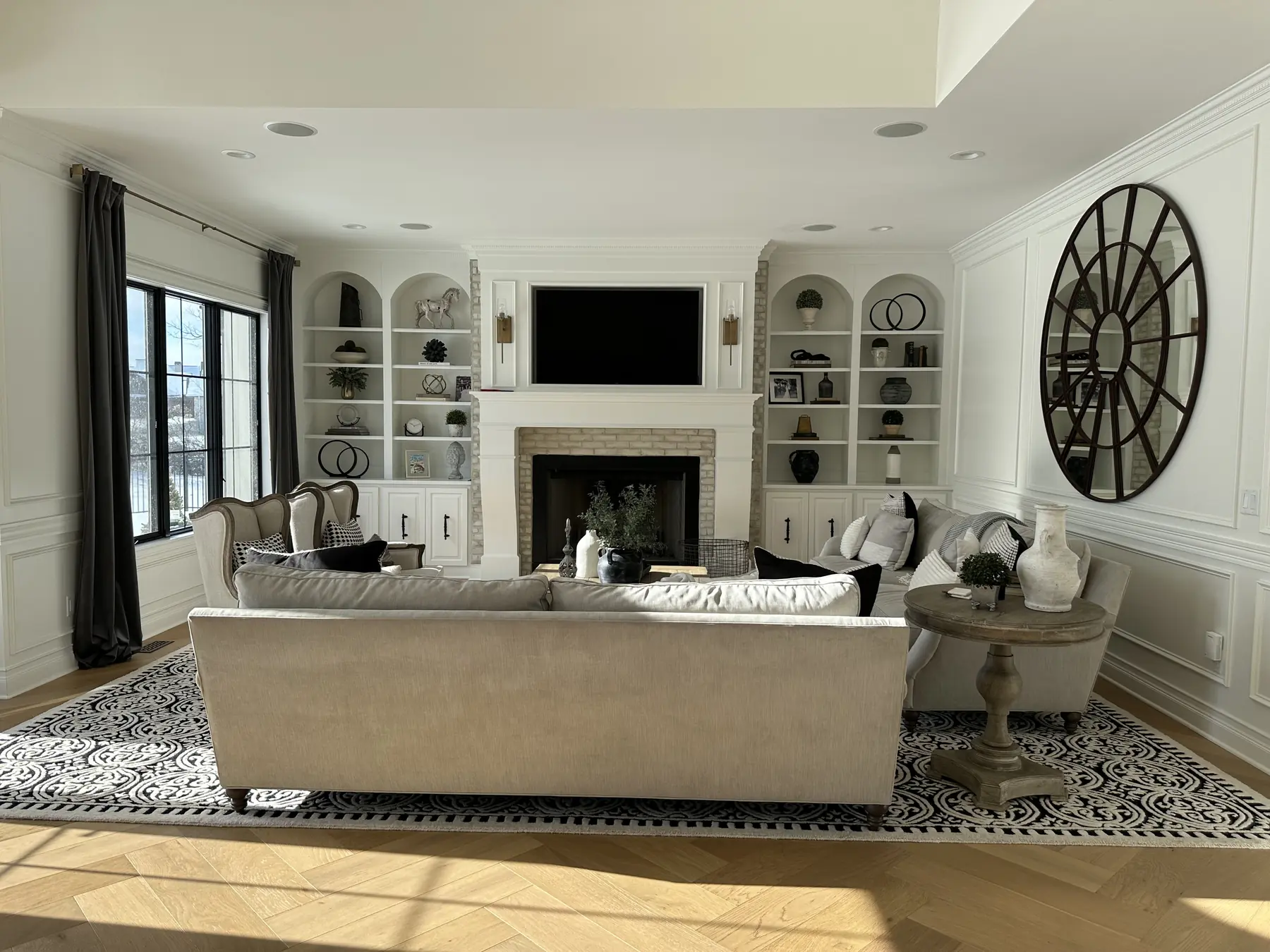 Living room in the French-Inspired Residence: a fireplace framed by arched built-ins