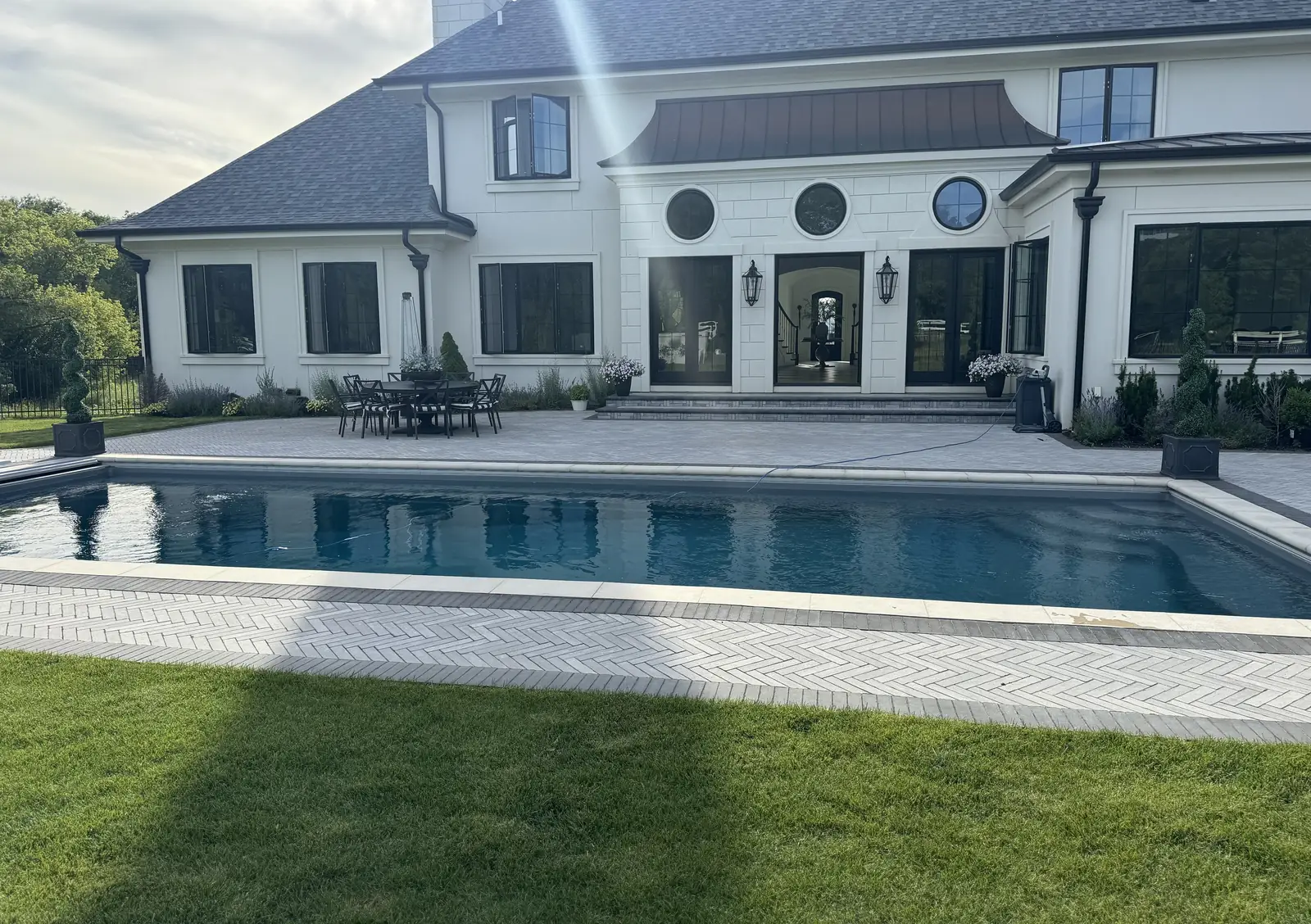 Herringbone paver pool deck — French-Inspired Residence