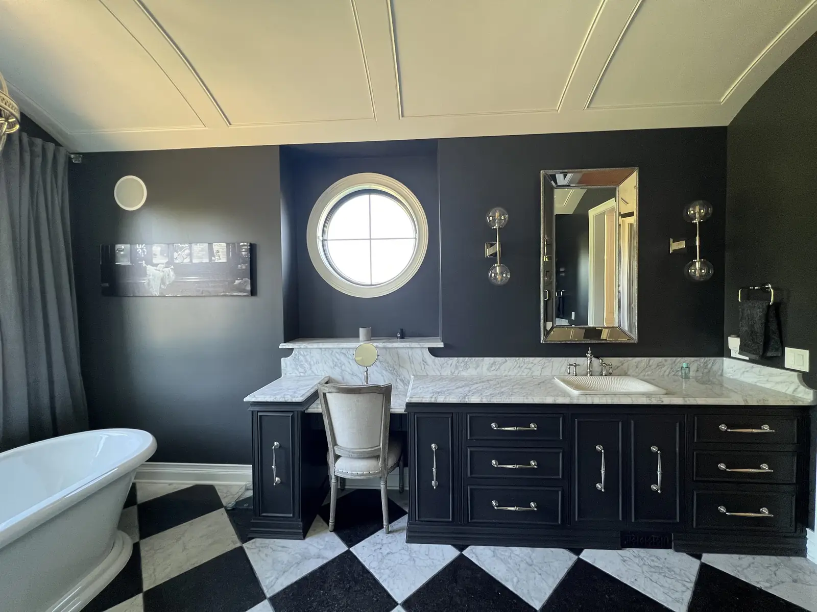 Vanity beneath an oculus window — French-Inspired Residence
