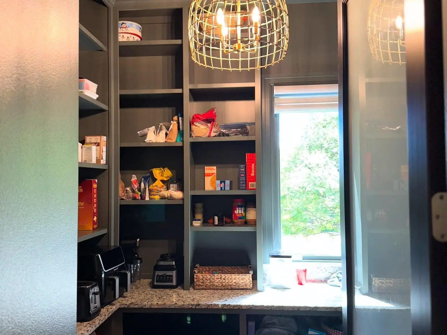 Pantry after — dark shelving framing the window
