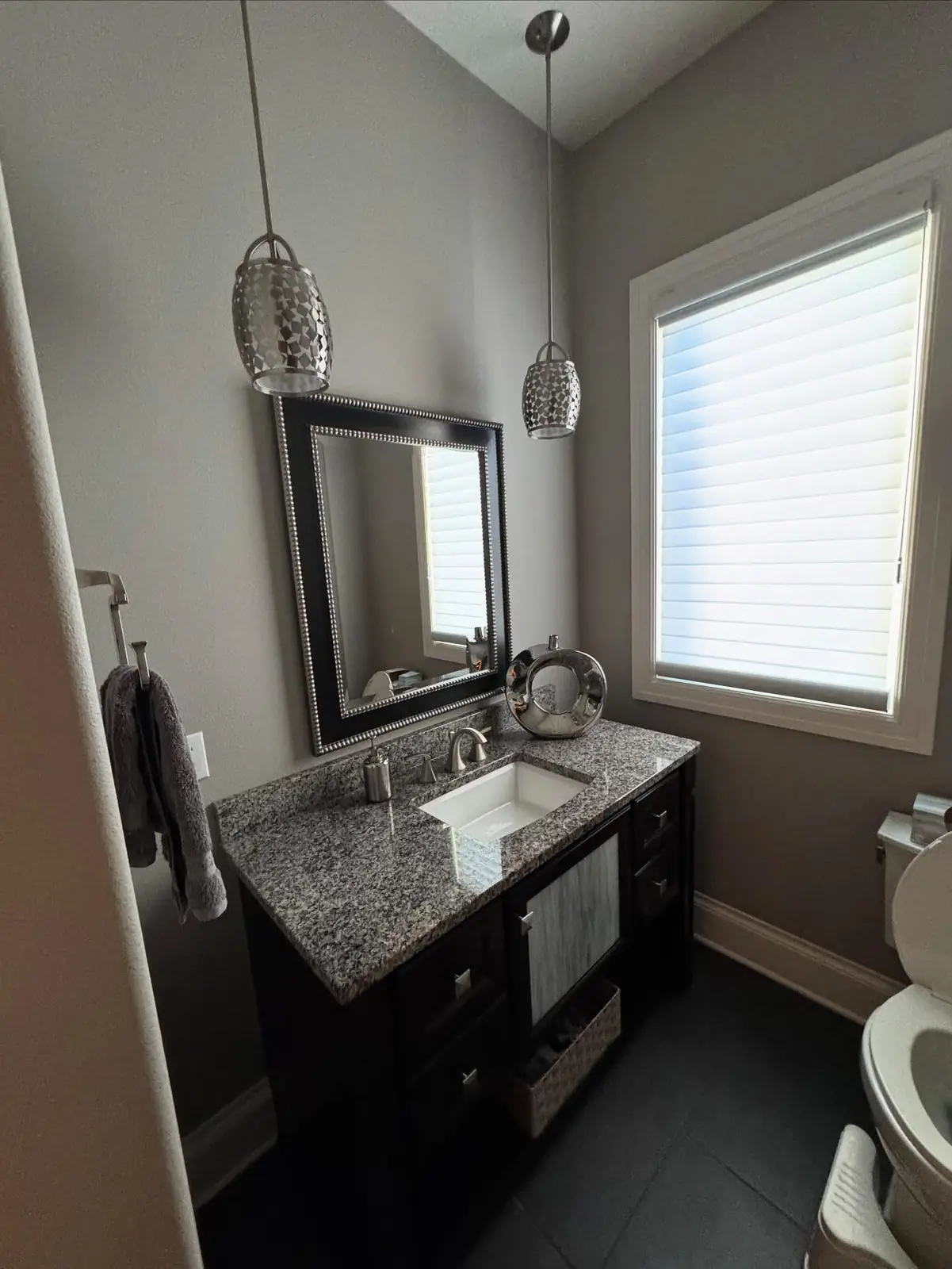 Powder room before — gray walls and a granite vanity