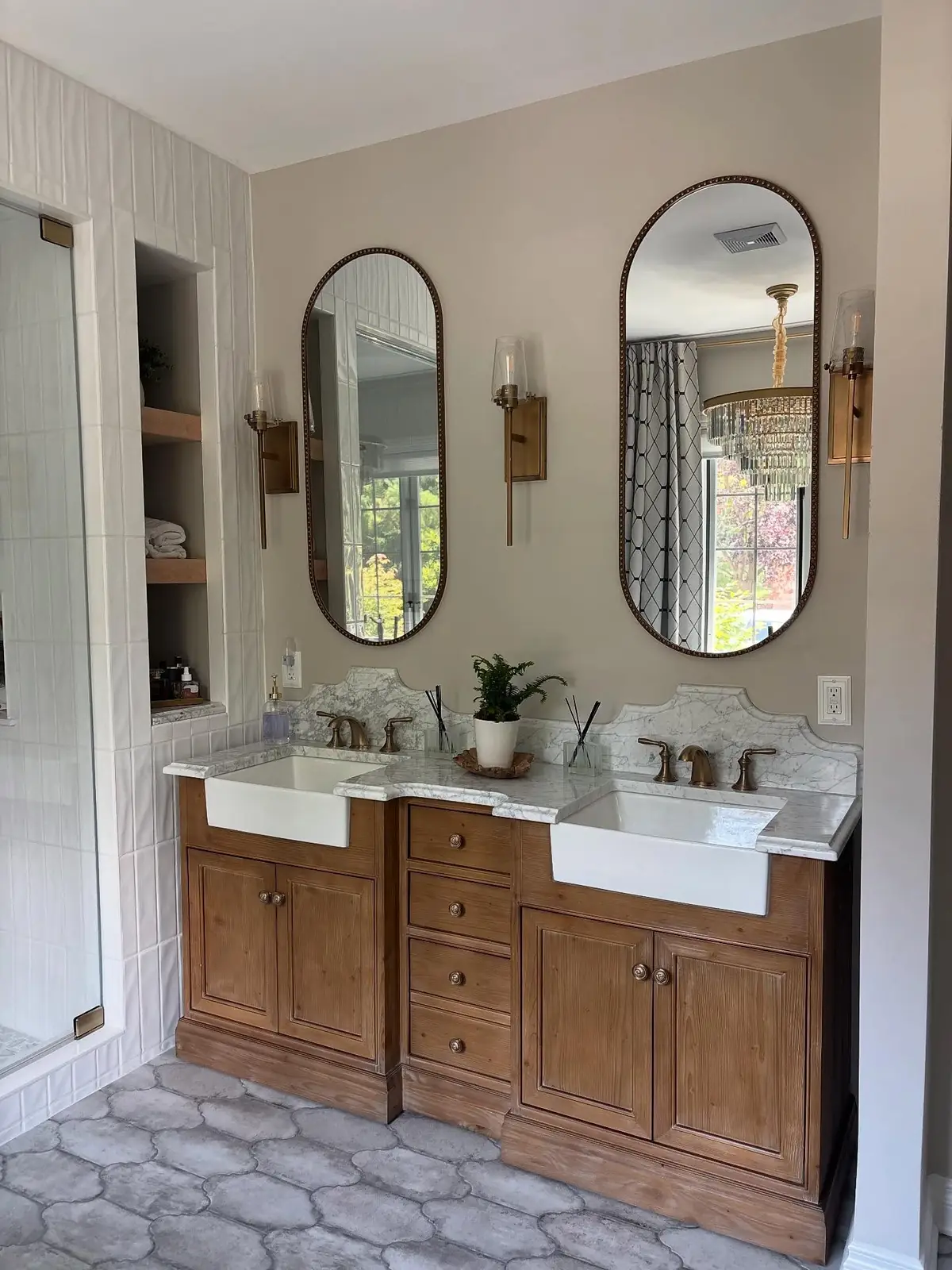 Primary bath vanity after — a wood double vanity with arched mirrors
