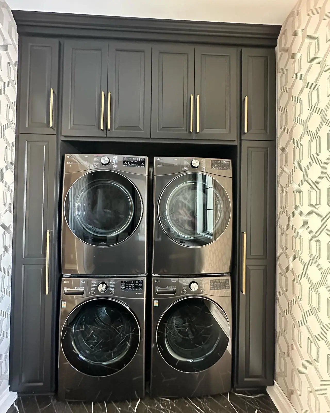 Laundry with stacked washers and dryers — French-Inspired Residence