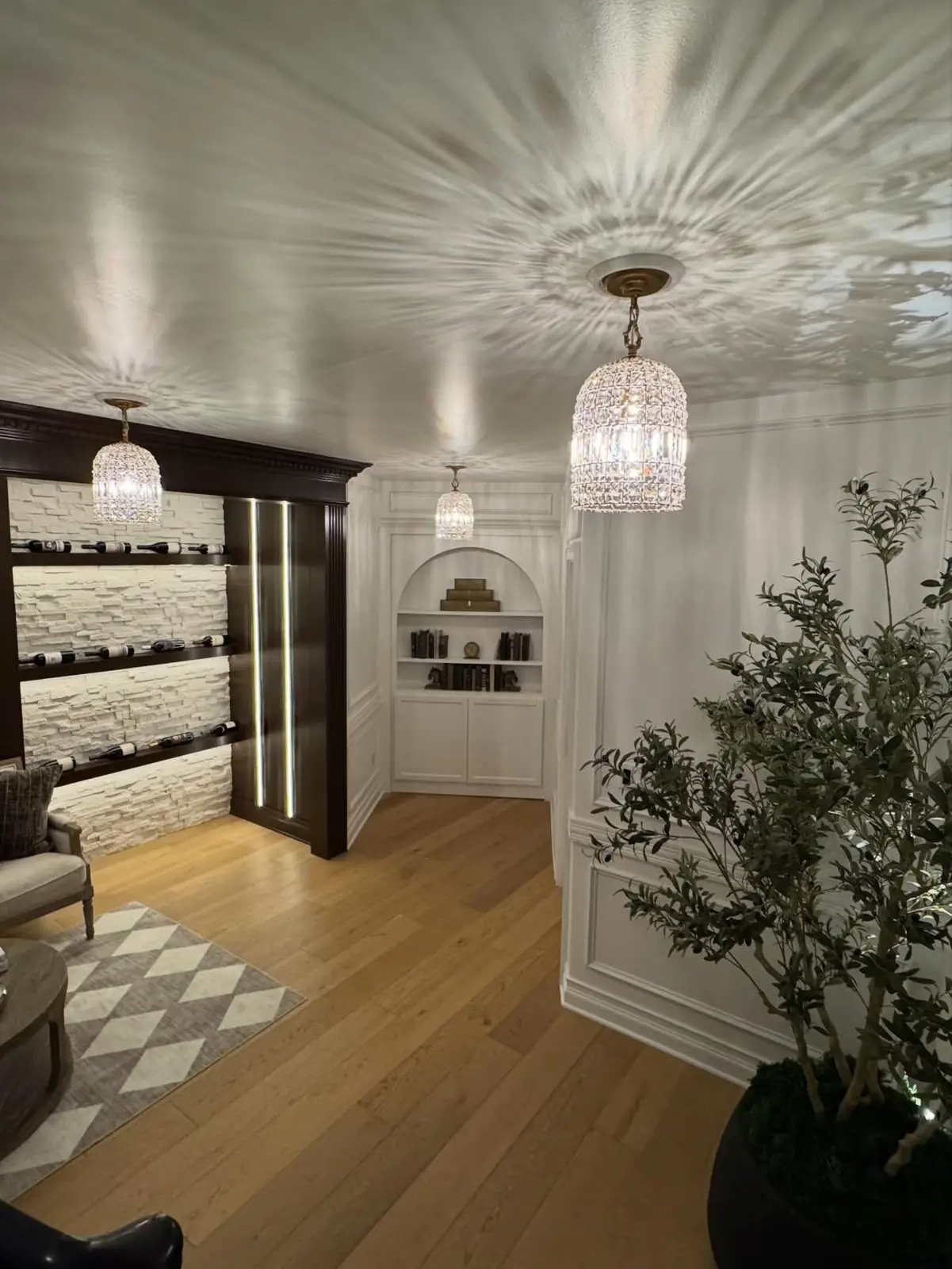 Foyer with an olive tree and display wall